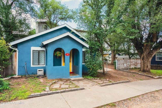 view of front of house featuring stucco siding and fence