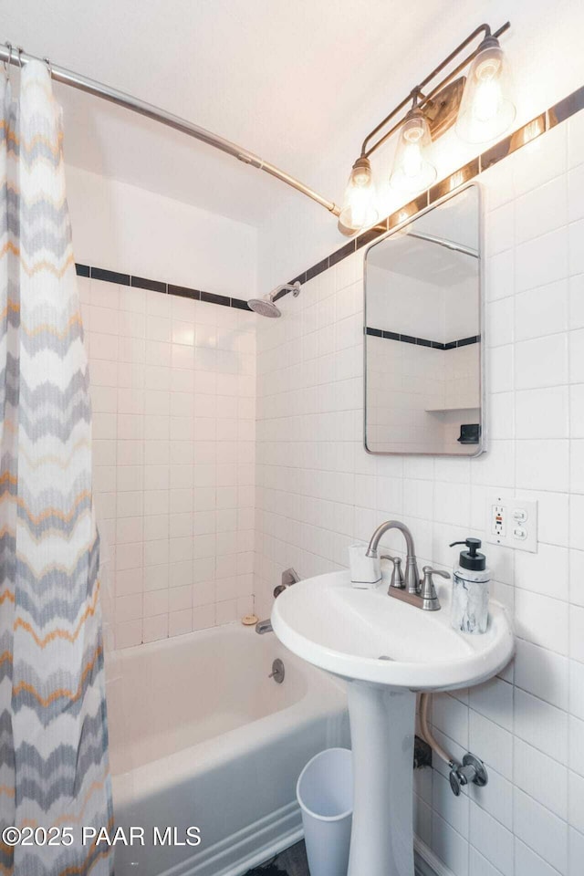 full bath featuring tile walls and shower / bath combo