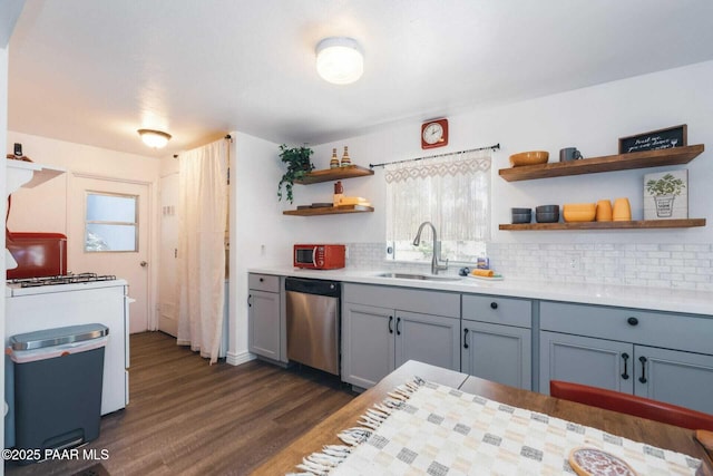 kitchen featuring open shelves, white range with gas cooktop, gray cabinetry, a sink, and dishwasher