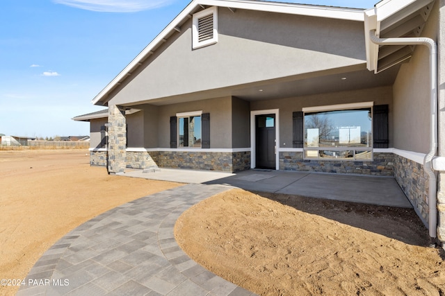 back of property with a patio area and stucco siding
