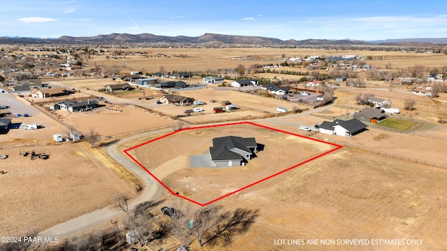 drone / aerial view featuring a rural view, a residential view, a desert view, and a mountain view