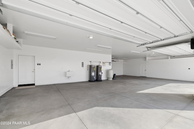 garage featuring water heater, a sink, and a garage door opener