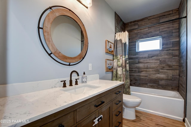 bathroom featuring toilet, wood finished floors, vanity, and shower / bath combination with curtain