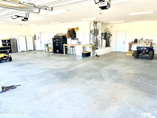 garage featuring gas water heater, heating unit, a garage door opener, and a workshop area