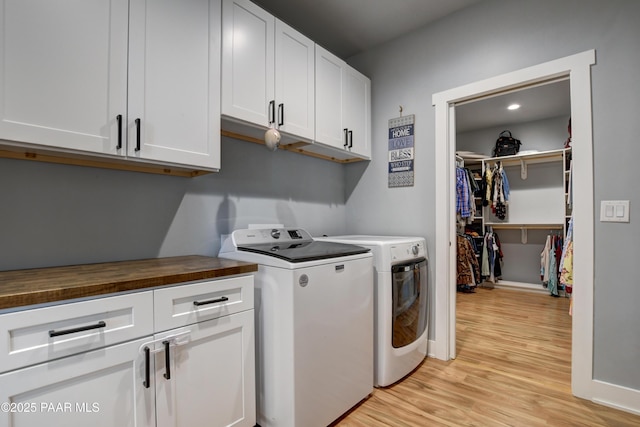 laundry area featuring cabinet space, independent washer and dryer, light wood finished floors, baseboards, and recessed lighting