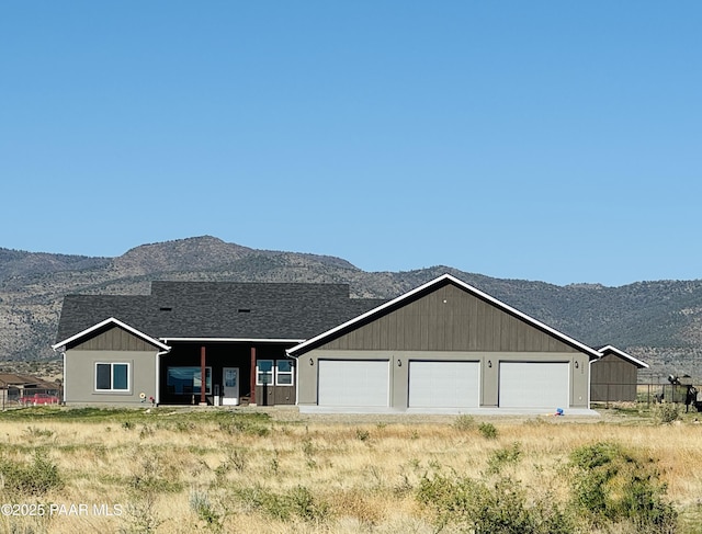 view of front of house featuring a garage, a mountain view, and a shingled roof