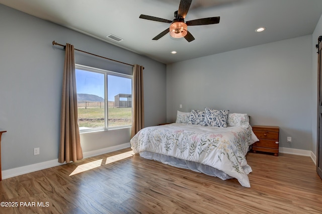 bedroom featuring wood finished floors, baseboards, recessed lighting, and ceiling fan