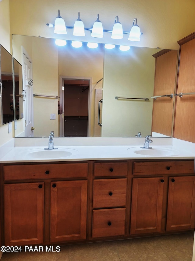 bathroom featuring tile patterned flooring, vanity, and a shower with shower door