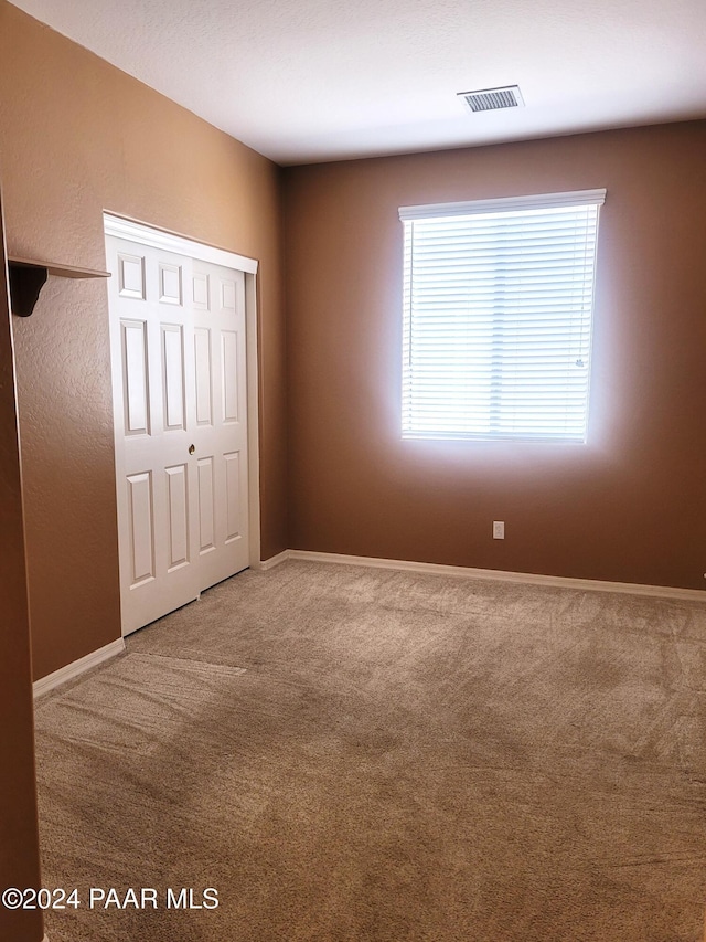 unfurnished bedroom with carpet floors and a closet