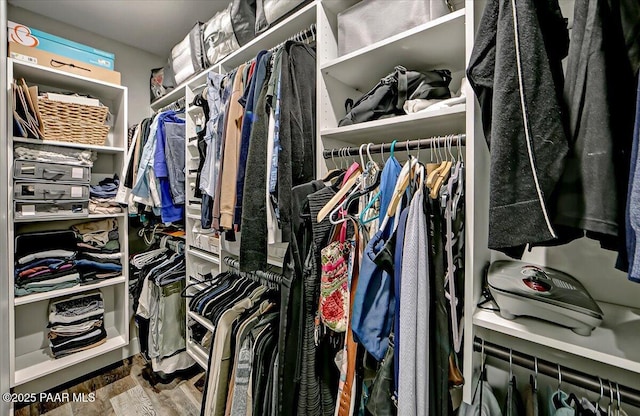 walk in closet with wood finished floors