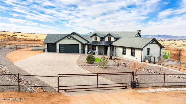 modern inspired farmhouse featuring a standing seam roof, board and batten siding, an attached garage, a fenced front yard, and driveway