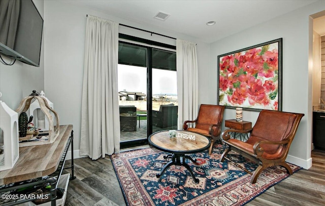 living area with recessed lighting, baseboards, visible vents, and wood finished floors