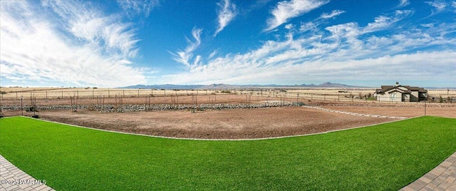 view of yard with fence, a mountain view, and a rural view