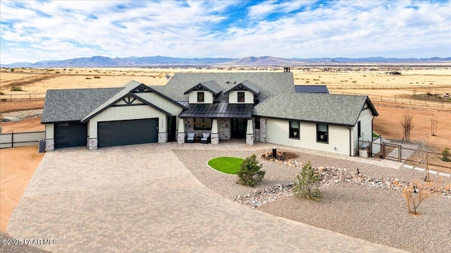 modern inspired farmhouse with an attached garage, decorative driveway, a mountain view, and fence