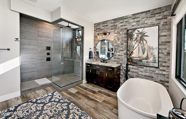 full bathroom featuring vanity, a soaking tub, wood finished floors, and a stall shower