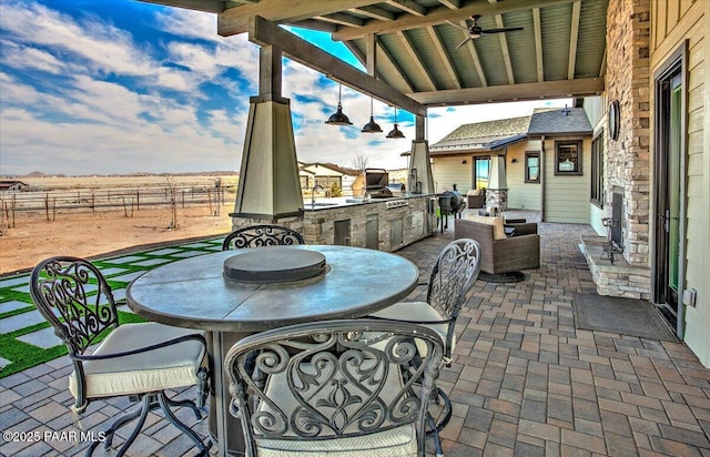 view of patio / terrace featuring outdoor dining area, fence, a sink, and area for grilling