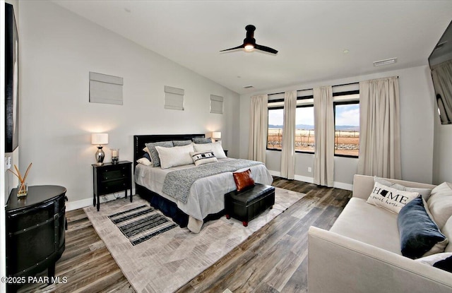 bedroom with baseboards, dark wood-style flooring, ceiling fan, and lofted ceiling