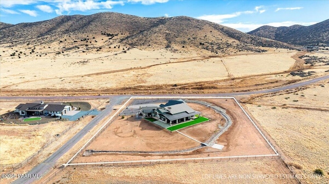 aerial view featuring a mountain view, view of desert, and a rural view