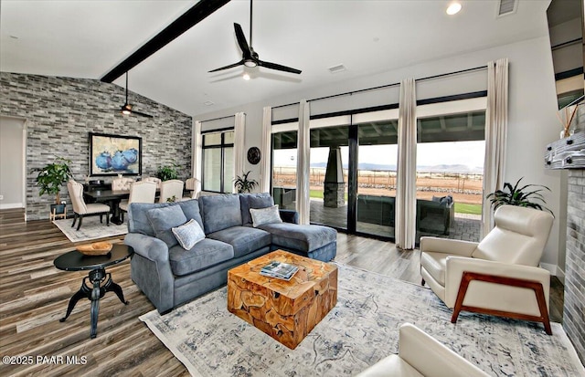 living room with ceiling fan, lofted ceiling with beams, baseboards, wood finished floors, and visible vents