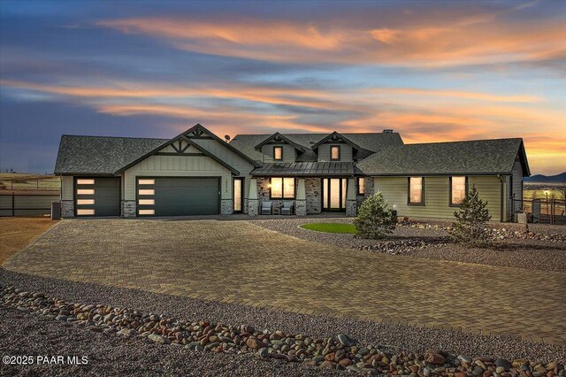 back of house at dusk featuring metal roof, a standing seam roof, a chimney, and a mountain view