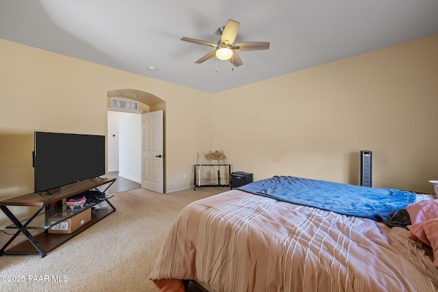carpeted bedroom featuring arched walkways, baseboards, ceiling fan, and visible vents