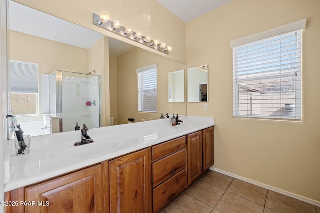 full bathroom with tile patterned floors, a sink, double vanity, and a shower stall