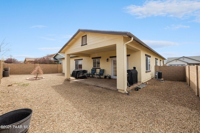 back of house featuring central air condition unit, stucco siding, a fenced backyard, and a patio area