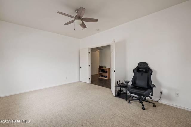 sitting room featuring a ceiling fan, carpet floors, and baseboards