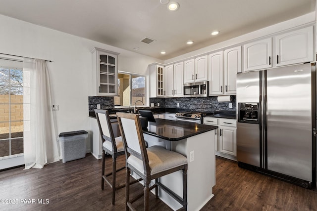 kitchen featuring glass insert cabinets, a wealth of natural light, visible vents, and stainless steel appliances