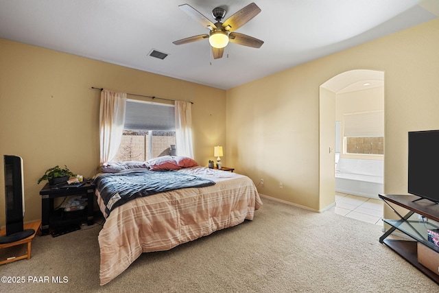 bedroom with carpet flooring, baseboards, tile patterned floors, ensuite bath, and visible vents