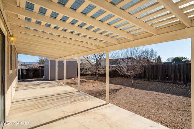 view of patio / terrace with an outdoor structure, a storage shed, and a fenced backyard