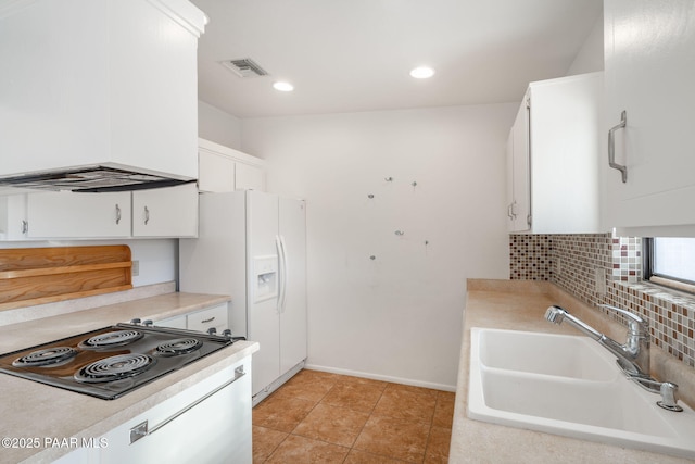 kitchen with visible vents, a sink, white refrigerator with ice dispenser, black electric stovetop, and tasteful backsplash