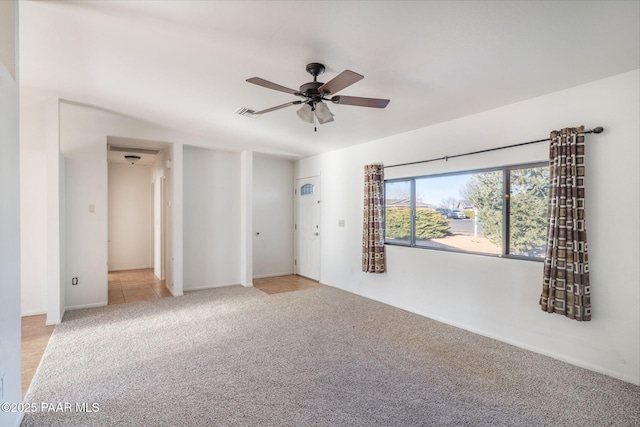 empty room featuring a ceiling fan, visible vents, and light carpet