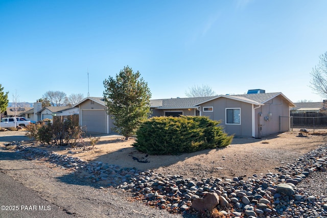 ranch-style home with a garage and fence