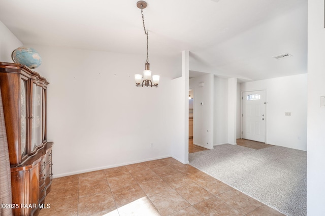 spare room with light carpet, a notable chandelier, baseboards, and visible vents