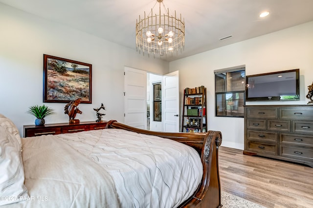 bedroom featuring light hardwood / wood-style flooring and a notable chandelier