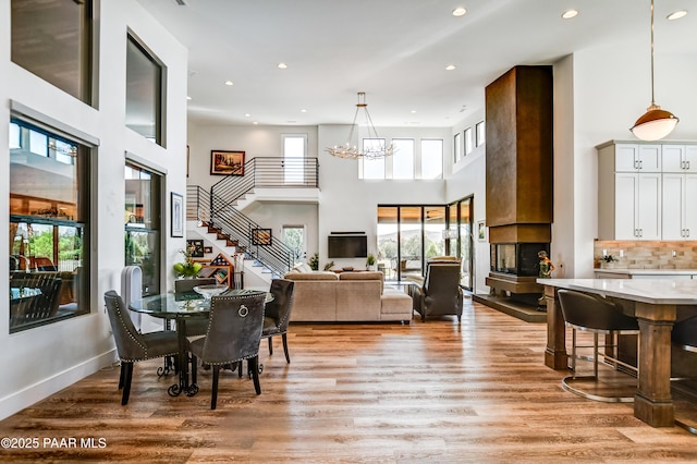 dining space featuring a high ceiling, light wood-type flooring, and a notable chandelier