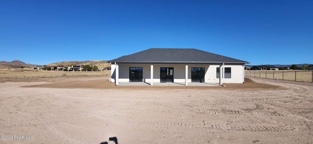 rear view of house with a mountain view and a patio