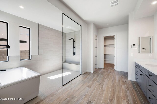 bathroom with vanity, wood-type flooring, and tiled shower