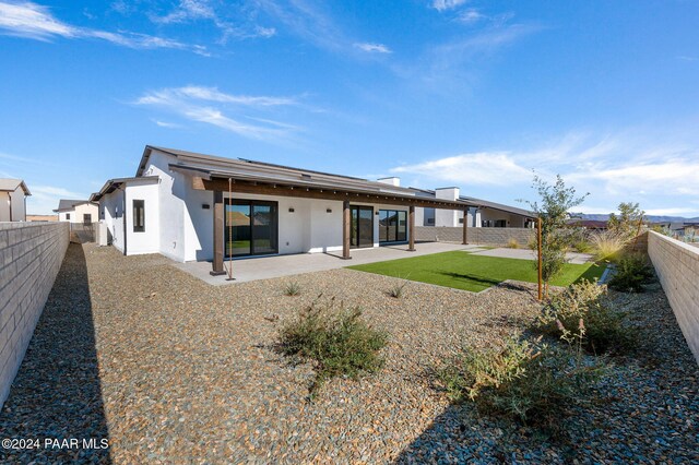 rear view of property with a patio and a lawn