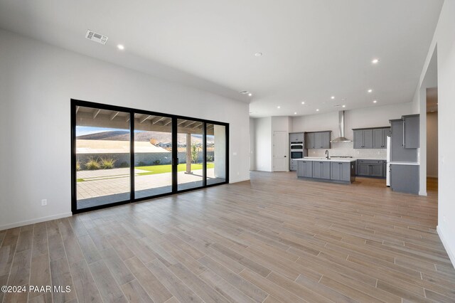 unfurnished living room with light hardwood / wood-style floors and sink