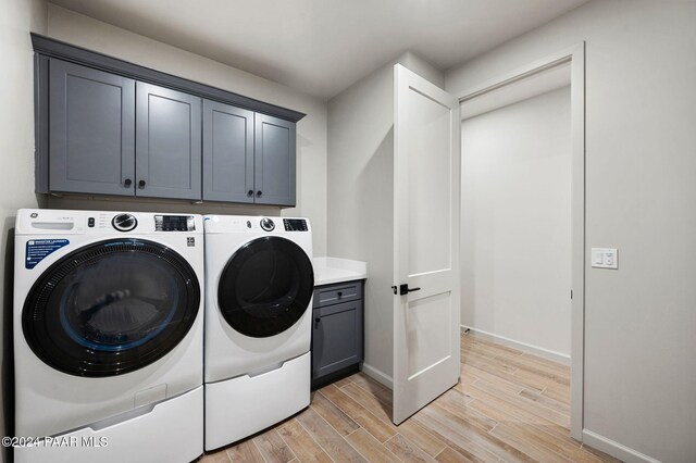 washroom with cabinets, light wood-type flooring, and separate washer and dryer