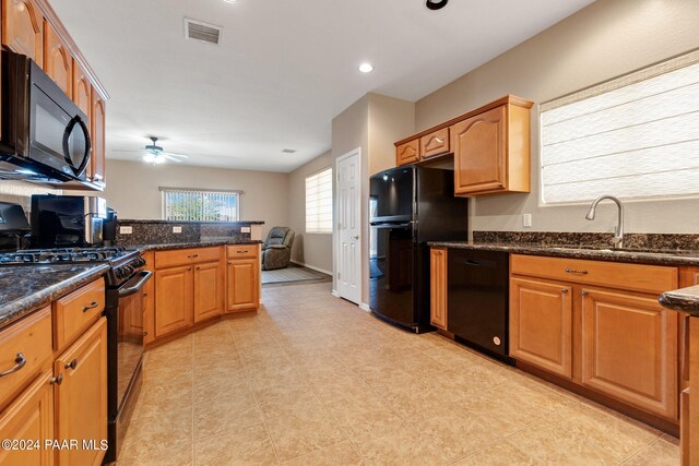 kitchen with dark stone counters, ceiling fan, sink, and black appliances