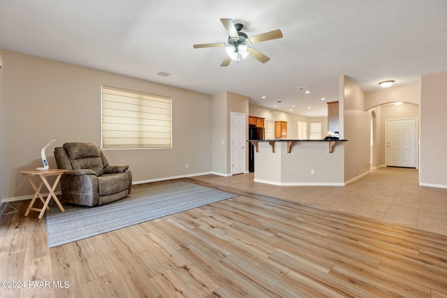 unfurnished living room with ceiling fan and light hardwood / wood-style flooring