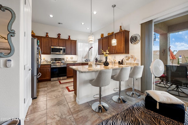kitchen with pendant lighting, recessed lighting, a peninsula, a kitchen breakfast bar, and stainless steel appliances