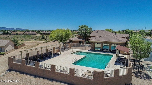 community pool with a patio and fence