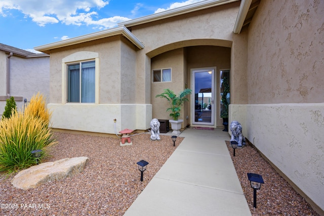 view of exterior entry with stucco siding