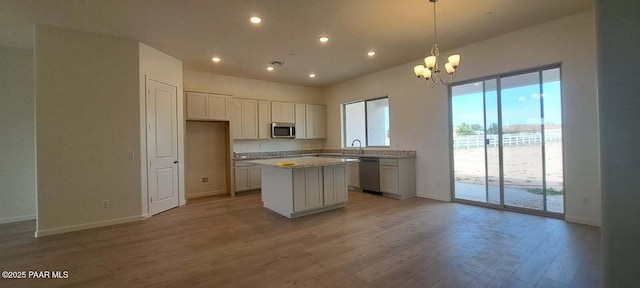 2535 Dillon Blvd, Chino Valley, AZ 86323 - kitchen featuring appliances with stainless steel finishes, a kitchen island, baseboards, light wood-style flooring, and a chandelier