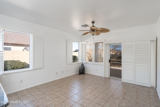 tiled spare room featuring ceiling fan and a wealth of natural light