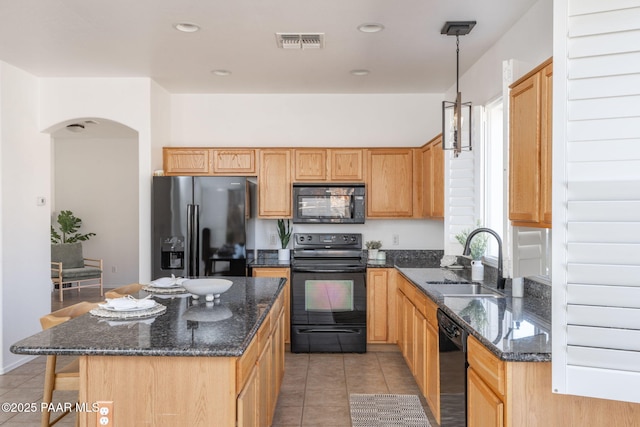 kitchen featuring light tile patterned floors, sink, hanging light fixtures, black appliances, and a kitchen island